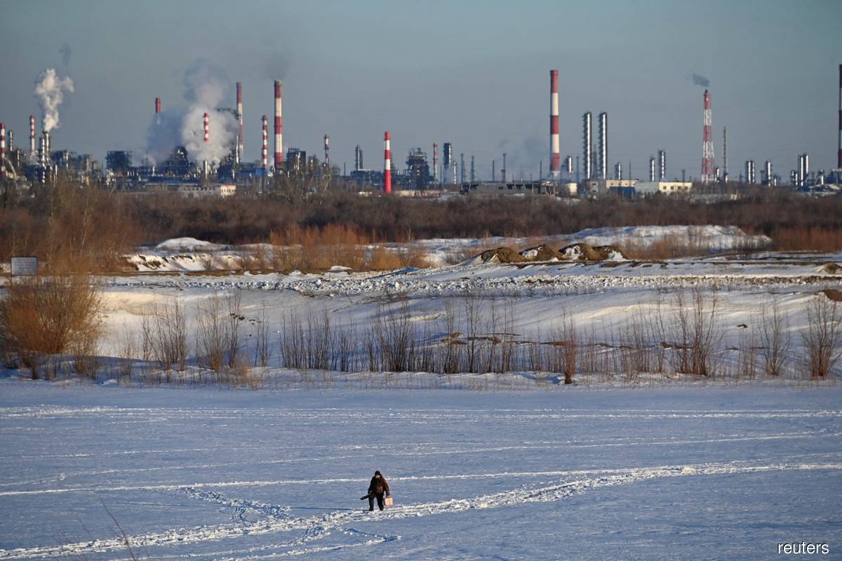  A fisherman walks on the ice-covered Irtysh River near an oil refinery and a thermal power station in the Siberian city of Omsk, Russia March 12, 2023. (Reuters pic)